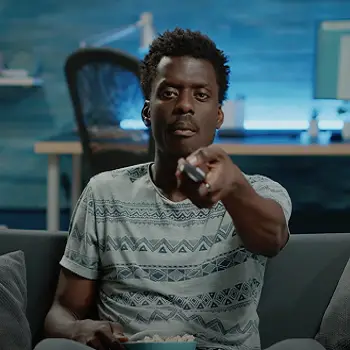 African American man with a television remote in his hand